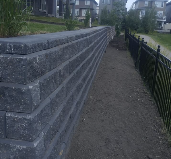 Elegant stone retaining wall creating tiered garden beds in Calgary.