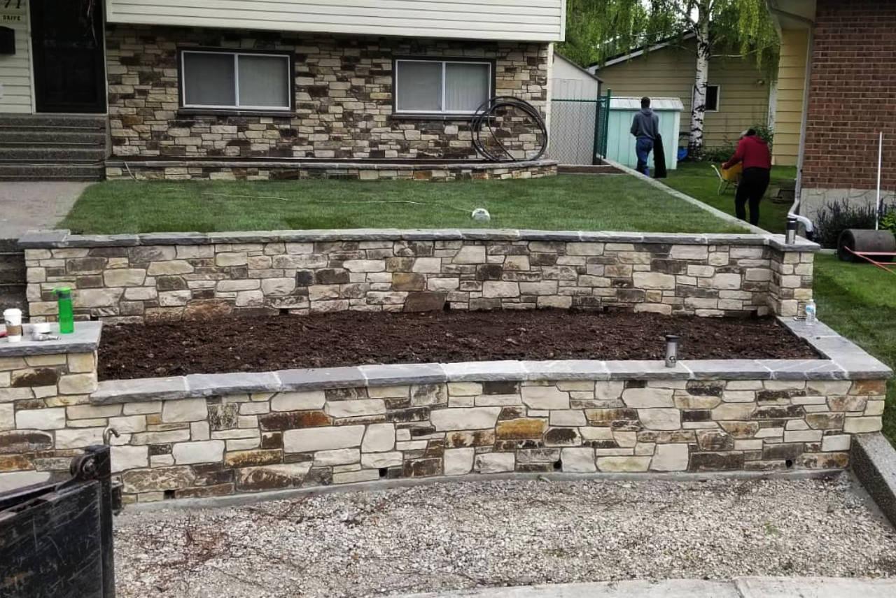 Expertly crafted natural stone retaining wall and pathway enhancing a property.