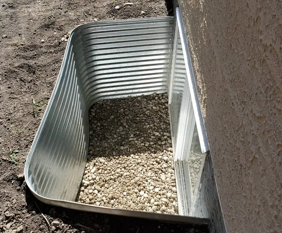 Clean and functional window well installation for a Calgary basement.